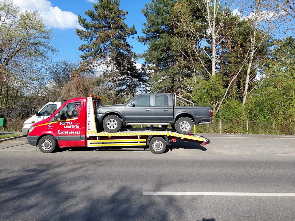 Pickup încărcat pe platforma firmei, pe marginea drumului